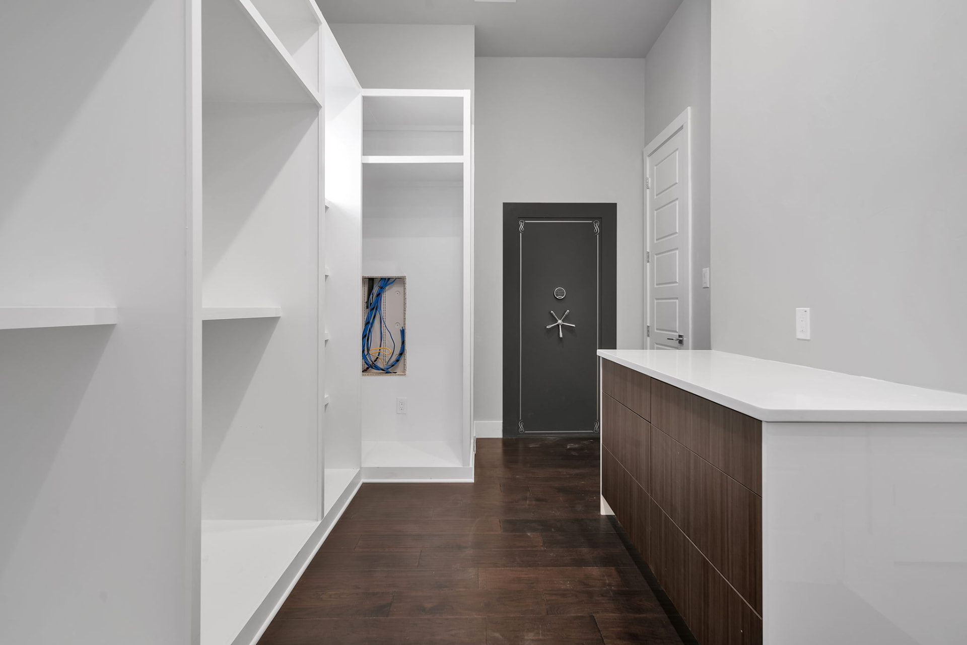 Closet and utility room with built in shelving and the reinforced safe room door