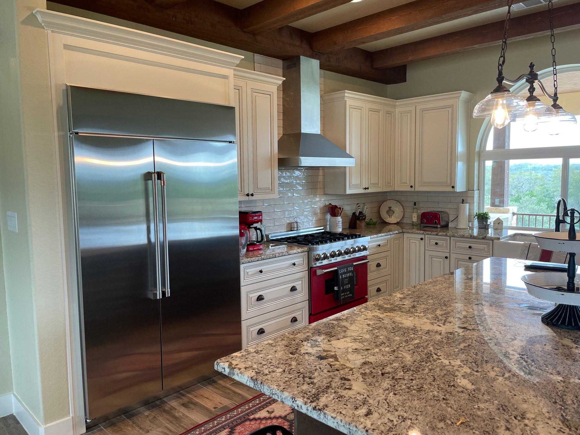 Kitchen and island looking toward the arched window and Hill Country view