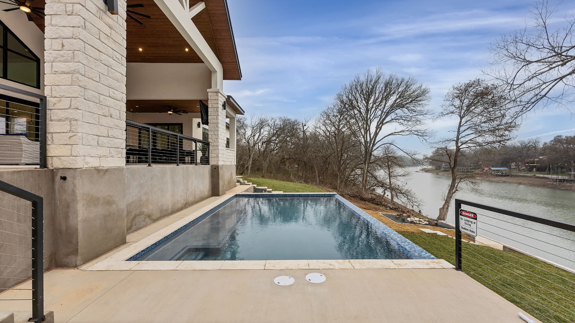 Pool deck and covered porch overlooking the water