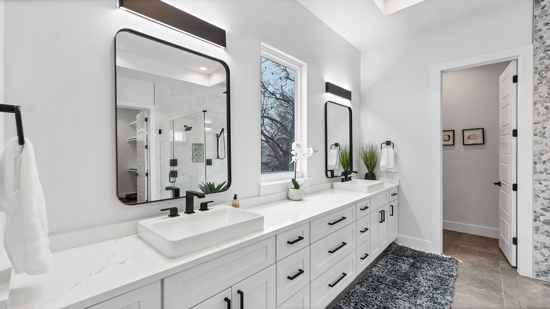 Primary bathroom double vanity with vessel sinks and black fixtures